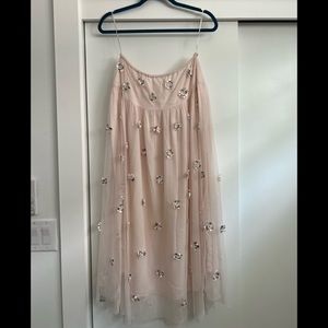 Long soft pink skirt with white and crystal floral attachments.